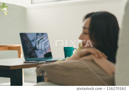 A woman taking a nap while working on a computer at home A woman taking a nap while working on a computer at home 116270162