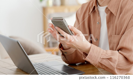 Man using a computer and smartphone 116270368