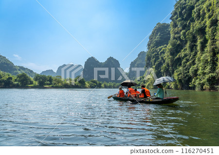 越南河內寧平遊船之旅的遊客乘坐划艇在山谷河流中航行 越南河內寧平遊船之旅的遊客乘坐划艇在山谷河流中航行 116270451