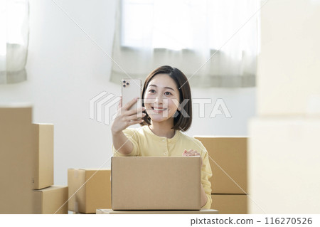 Moving image: Young woman holding a smartphone 116270526