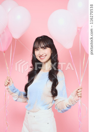 Portrait of a female college student holding a pink balloon Portrait of a female college student holding a pink balloon 116270538