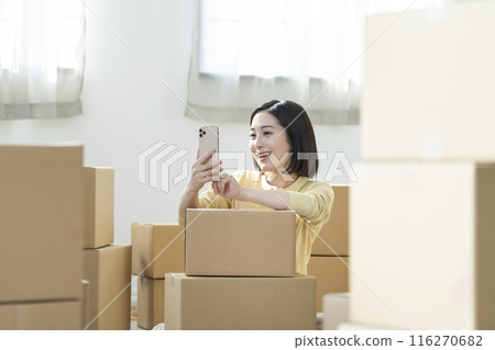 Moving image: Young woman holding a smartphone 116270682