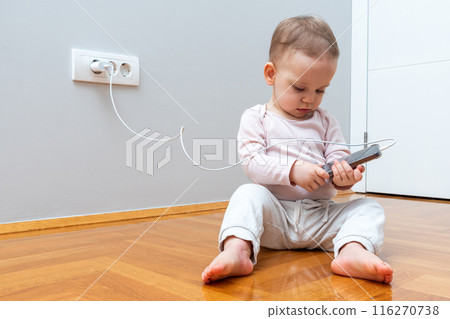 Baby busy playing with smartphone. Next generation concept Baby busy playing with smartphone. Next generation concept 116270738