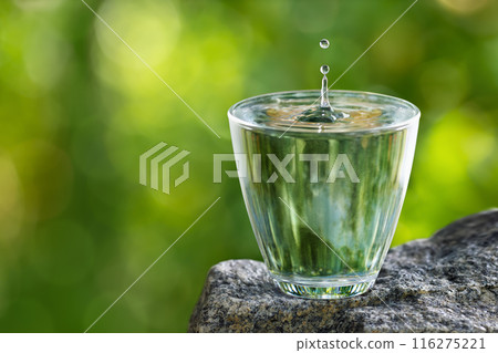 glass of drinking water with splash and drop on stone glass of drinking water with splash and drop on stone 116275221