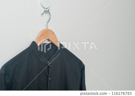 hanging shirt with wood hanger on wall 116276783