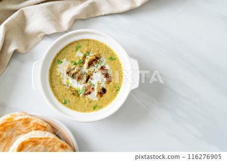 Afghani chicken in green masala curry or Hariyali tikka chicken hara masala with roti or naan bread 116276905