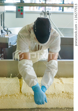 A man demonstrates how to cut tofu in a factory A man demonstrates how to cut tofu in a factory 116277013