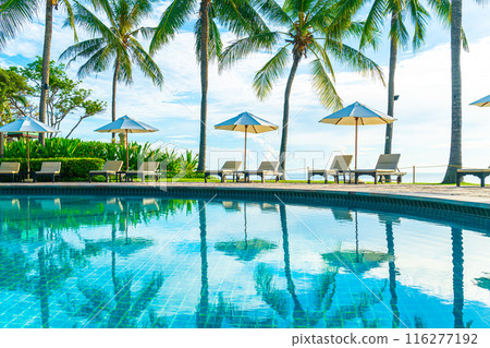 Beautiful luxury umbrella and chair around outdoor swimming pool in hotel and resort with coconut palm tree on sunset or sunrise sky Beautiful luxury umbrella and chair around outdoor swimming pool in hotel and resort with coconut palm tree on sunset or sunrise sky 116277192