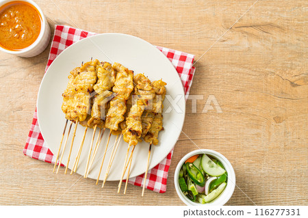 Pork satay with peanut sauce pickles which are cucumber slices and onions in vinegar 116277331