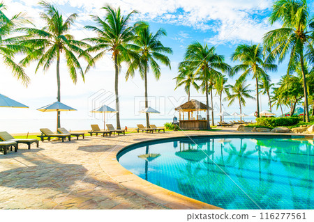 Beautiful luxury umbrella and chair around outdoor swimming pool in hotel and resort with coconut palm tree on blue sky 116277561