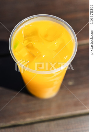 Orange lemonade with ice in a glass on the street. Summer citrus refreshing drink 116278392