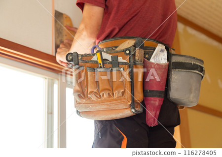 A craftsman replacing wallpaper on a house 116278405