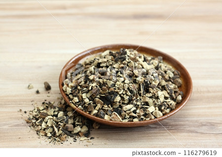 Dried roots of comfrey, lat. Symphytum officinale on wood table. 116279619