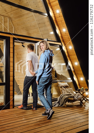 A husband and wife enter the house after an evening walk 116279732