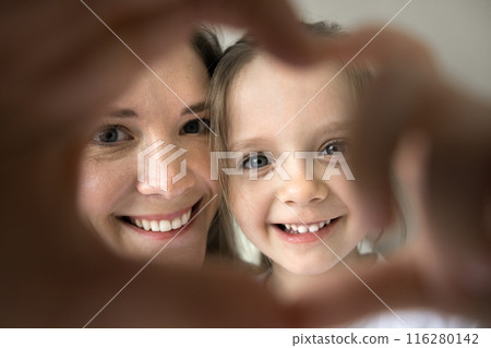 Closeup mother and daughter showing heart symbol with joined fingers 116280142