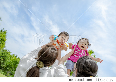 Mothers holding their children up in the park Mothers holding their children up in the park 116280449