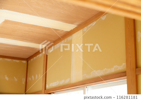A wall in a used house undergoing renovation with the wallpaper removed 116281181