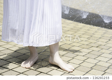 A woman's feet cooling off in a park fountain [Part cut] 116281233
