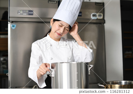 Asian female chef worried in front of a cooking pot 116281312