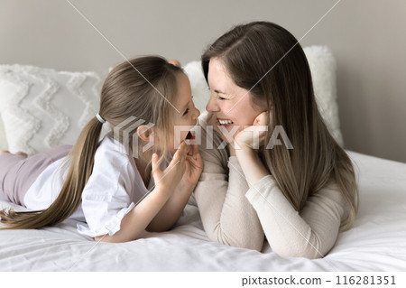 Cheerful mom and daughter look at each other with love Cheerful mom and daughter look at each other with love 116281351