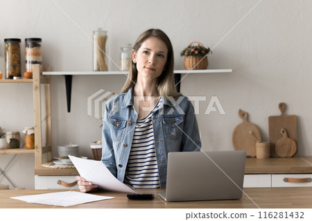 Pensive woman stand at kitchen table do paperwork 116281432