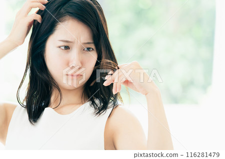 一位年輕女性擔心頭髮受損 一位年輕女性擔心頭髮受損 116281479