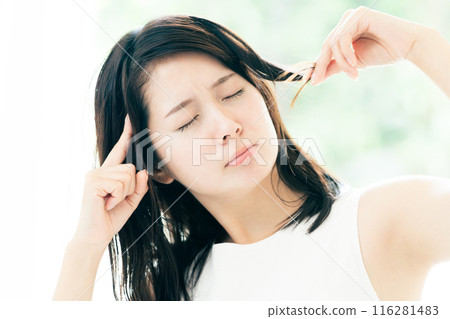 A young woman who is concerned about damaged hair 116281483