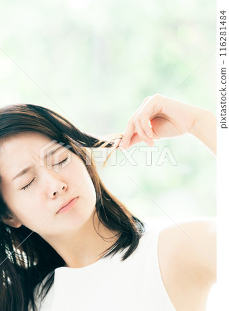 一位年輕女性擔心頭髮受損 116281484