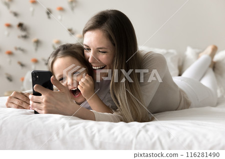 Woman and daughter laughing while watching funny videos on internet Woman and daughter laughing while watching funny videos on internet 116281490