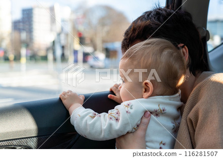 A child in a car looks out the window with interest. Concept of unsafe transportation of children 116281507