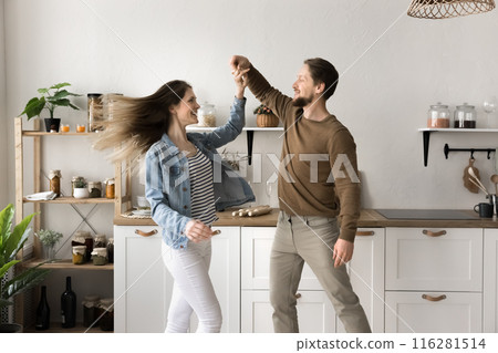 Young couple in love holding hands and dancing in kitchen 116281514