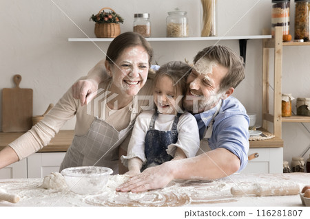 Playful parents and daughter having fun while preparing dough 116281807