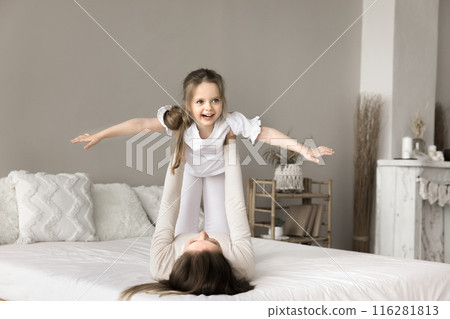 Carefree little girl playing with mother in bedroom Carefree little girl playing with mother in bedroom 116281813