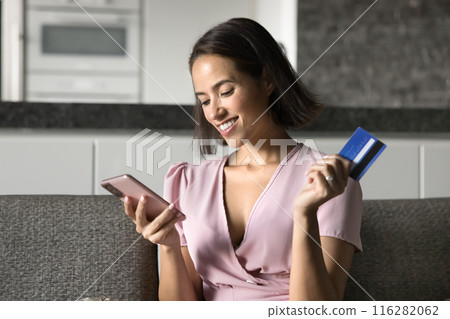 Happy positive young bank customer woman using credit card Happy positive young bank customer woman using credit card 116282062