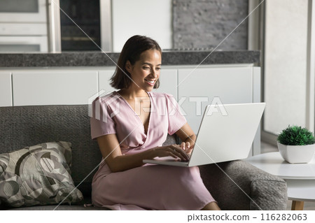 Positive young freelance entrepreneur woman typing on laptop Positive young freelance entrepreneur woman typing on laptop 116282063