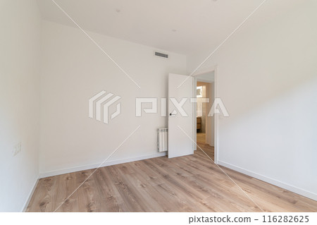 The room is modern with white walls and wooden flooring, creating a bright and clean space The room is modern with white walls and wooden flooring, creating a bright and clean space 116282625
