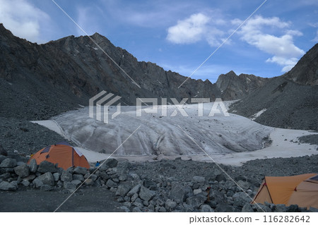 Camping near the glacier among the mountains under the blue sky with white clouds Camping near the glacier among the mountains under the blue sky with white clouds 116282642