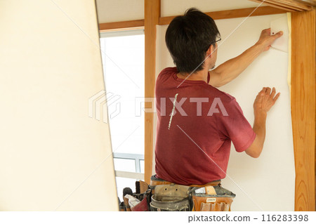 一位工匠正在重新覆蓋房屋的布料 116283398