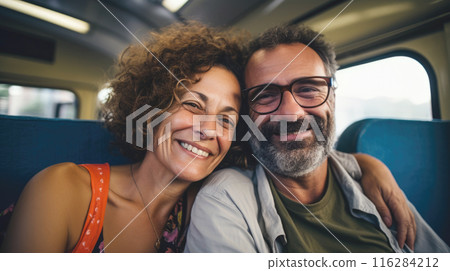 Cheerful mature couple travelling by train, responsible travel concept 116284212
