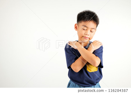 Happy young child smiling Asian boy hugging herself remember a moment studio short isolated on white background, Self care and self esteem concept, Lifestyle primary kid love yourself carefree 116284387