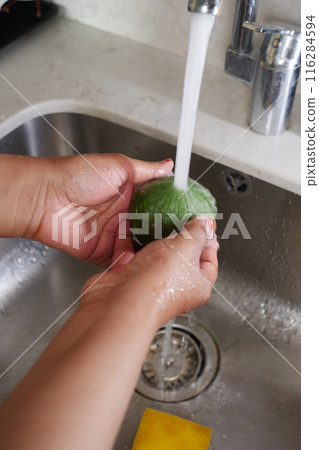 hand washing avocado with water sprinkling hand washing avocado with water sprinkling 116284594