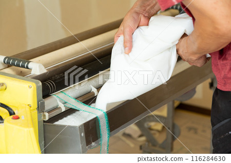 A craftsman preparing wallpaper for a house 116284630
