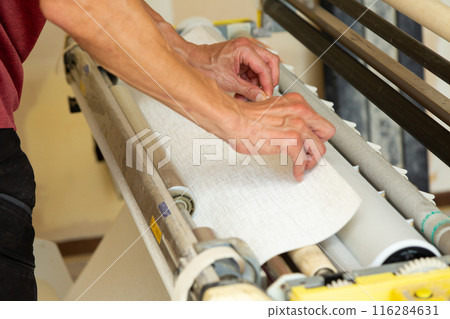 A craftsman preparing wallpaper for a house 116284631