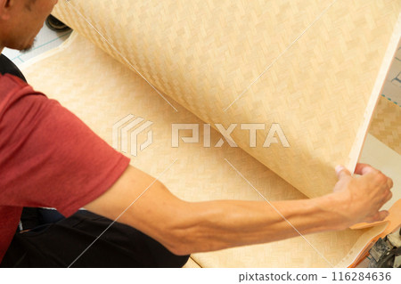 A craftsman preparing wallpaper for a house 116284636