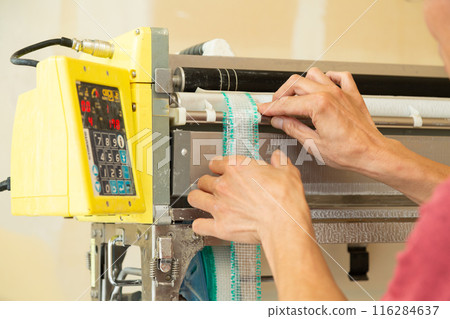 A craftsman preparing wallpaper for a house 116284637