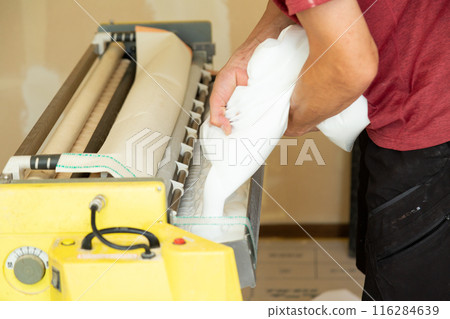 A craftsman preparing wallpaper for a house A craftsman preparing wallpaper for a house 116284639