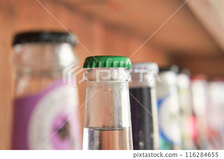 Vintage beverage bottles with colorful caps on bar shelf create a nostalgic retro drinks display 116284655