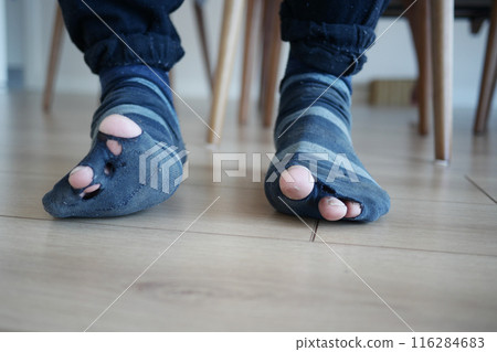 men feet with dirty socks while sitting on sofa  116284683