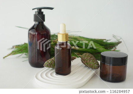 Bottle of pine essential oil and tree branch on white background 116284957