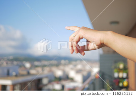 A closeup image of a female hand pointing over water in a natural outdoor setting A closeup image of a female hand pointing over water in a natural outdoor setting 116285152